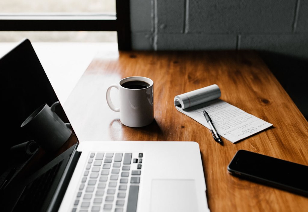 Laptop, notebook, and coffee - ready to work.